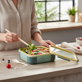 Tiny Tokens kids 3-section bento lunch box in mint green with yellow trim, includes spork and transparent lid.