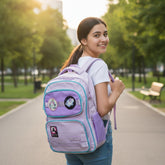 Tiny Tokens lavender and lilac unicorn backpack with 3 embroidered badges and teal trim. Features star pocket and reflective details.