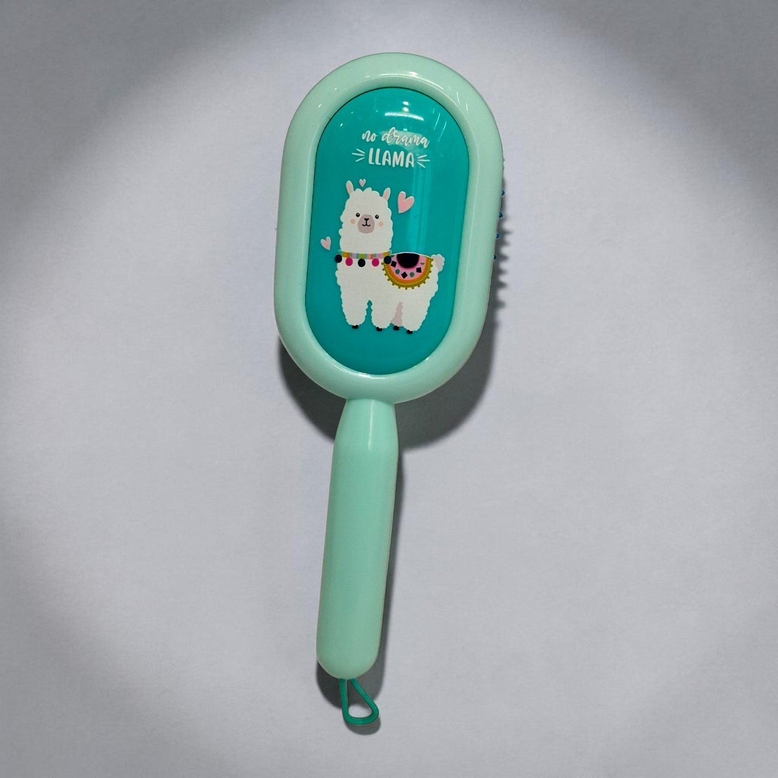 Tiny Tokens mint green cartoon hair brush with a llama design and soft bristles, ideal for detangling kids' hair.