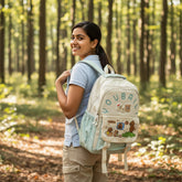Tiny Tokens mint green and cream two-tone school backpack with capybara comic flap and 3D bear patch.