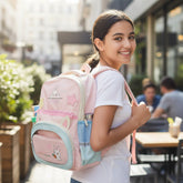 Tiny Tokens pastel pink backpack with 3D bunny ears, star patches, and cute bunny illustrations. Features multiple pockets and a reflective strip.