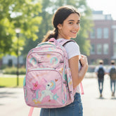 Tiny Tokens pink polyester unicorn backpack with all-over print, "Life is Magical" text, and teal mesh pockets.