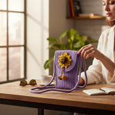Tiny Tokens purple woven rope sling bag for kids with sunflower appliqué and charm danglers. Features magnetic snap closure and comfortable rope strap.
