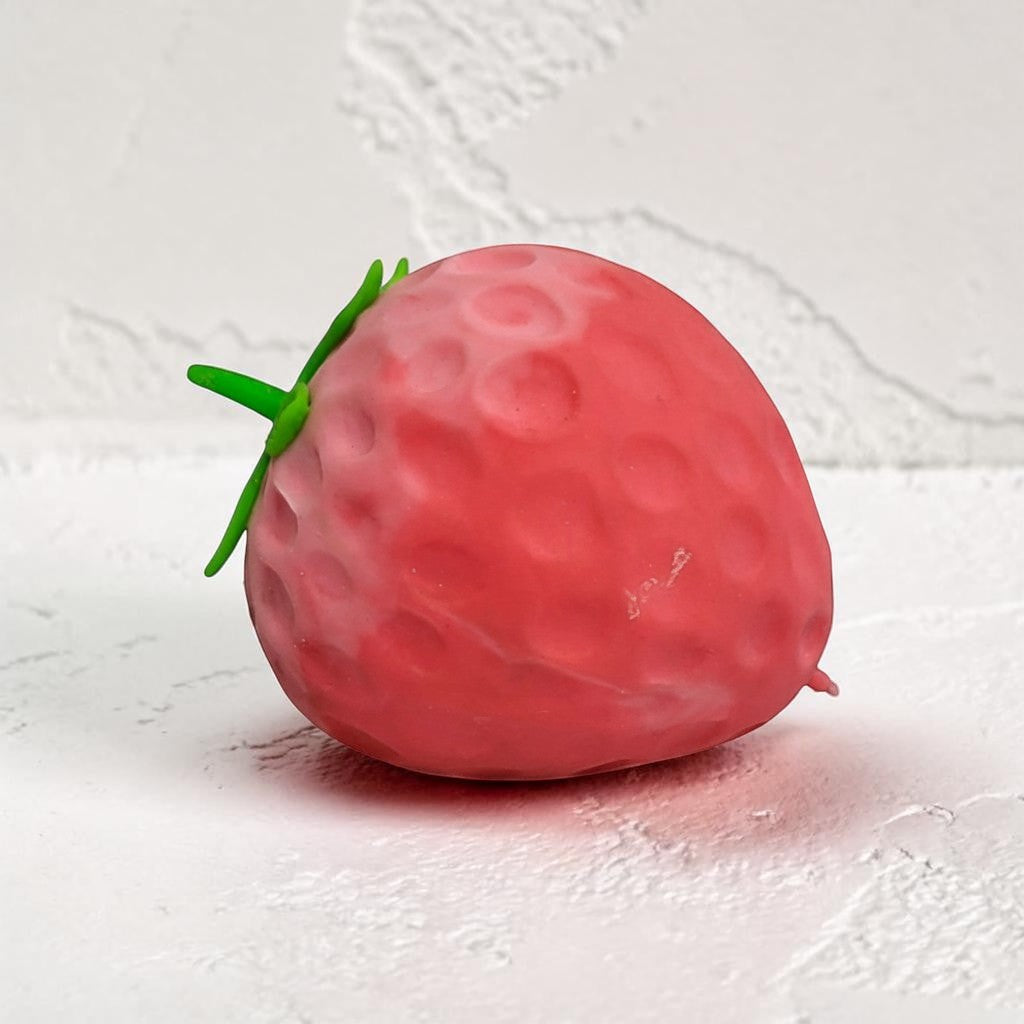 Tiny Tokens red strawberry stress relief toy with green stem, made of soft rubber for sensory play.