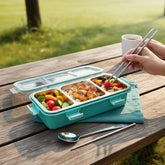 Tiny Tokens teal 3-section stainless steel lunch box with spoon and chopsticks, clear lid with green seal.