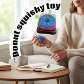 Tiny Tokens blue and pink donut squishy toy held in hand, made of soft silicone for stress relief.