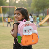 Tiny Tokens pink neoprene toddler backpack with 3D plush bunny and carrot pocket. Features adjustable straps and mesh side pockets.