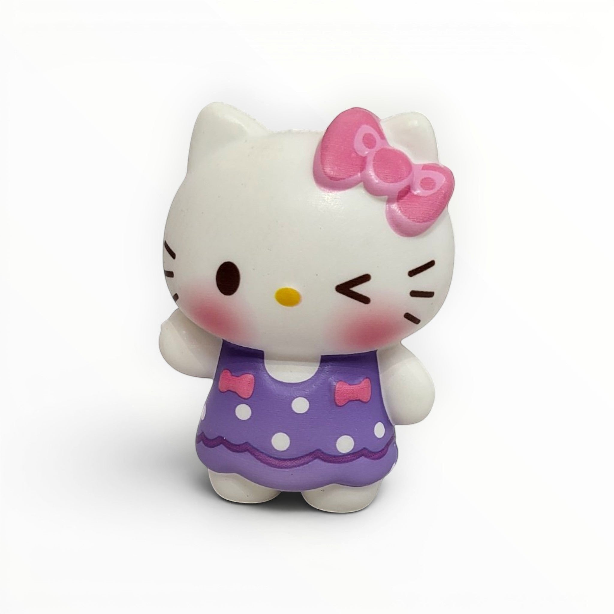 Tiny Tokens white cat squishy toy with pink bow and purple polka dot dress, winking and blushing.