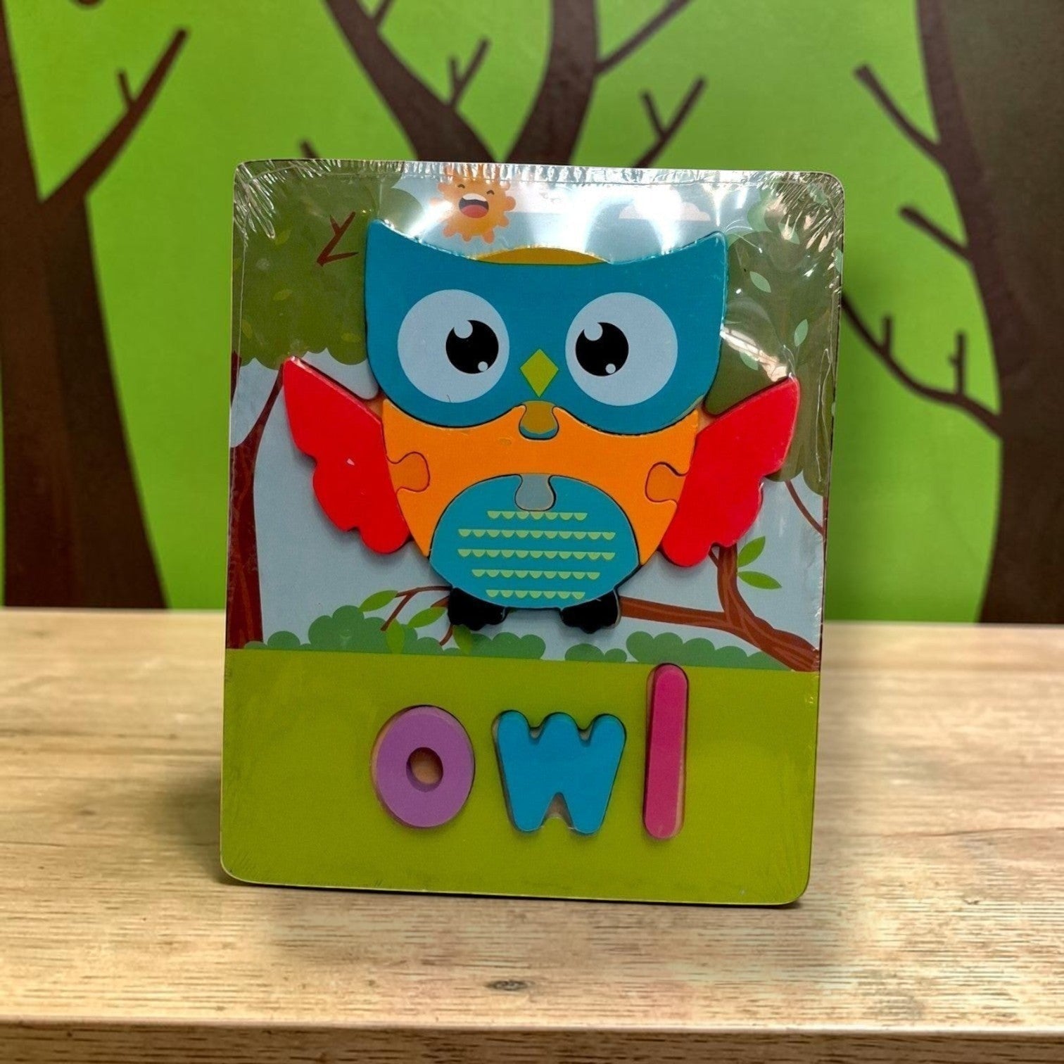Tiny Tokens wooden owl puzzle board with chunky 3D letter pieces spelling 'owl'. Features a colourful owl illustration on a forest background.