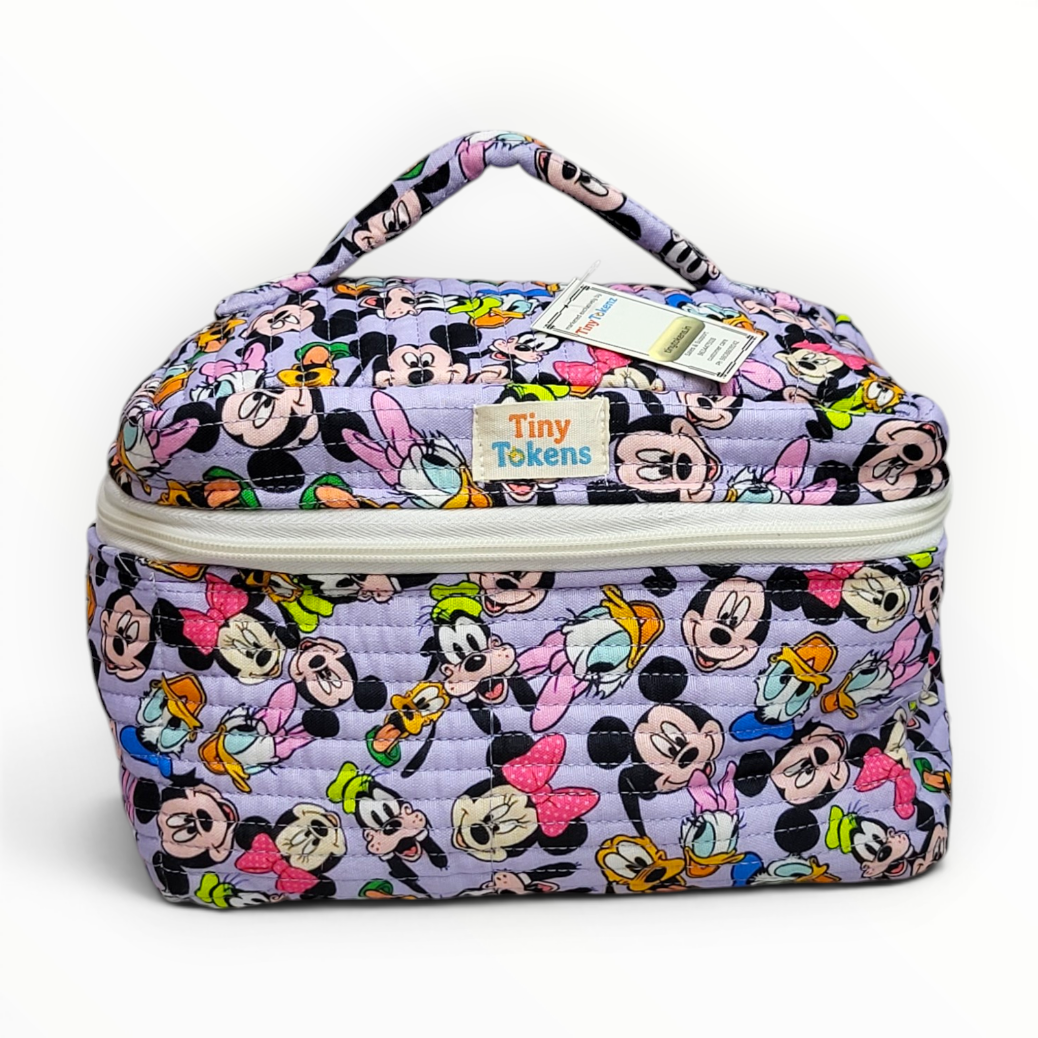 Front view of a lavender quilted cotton kids lunch and vanity bag featuring an all-over classic Disney characters print and a "Tiny Tokenz" fabric brand label.