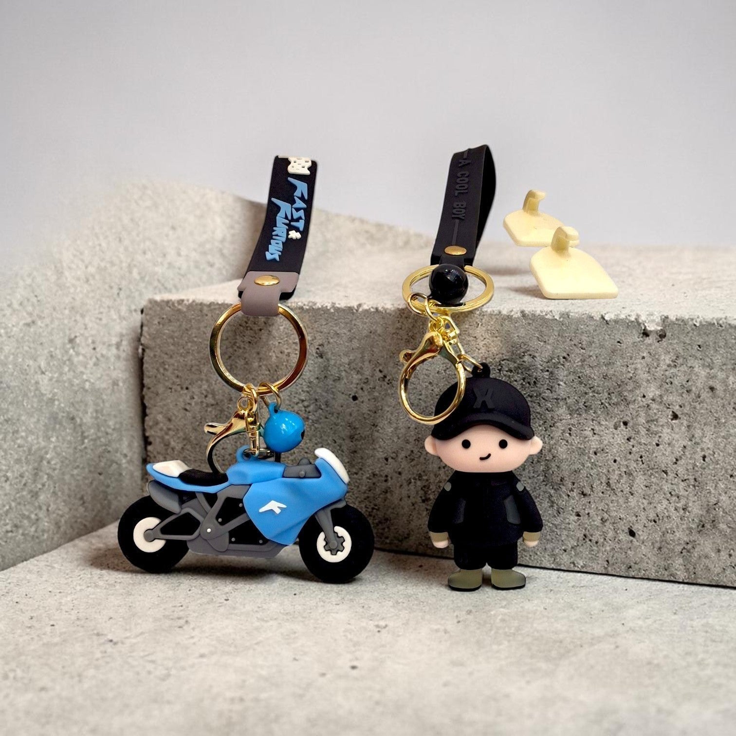 Tiny Tokens blue 3D rubber motorcycle keychain with "Fast & Furious" strap and a separate 3D rubber boy keychain with "A Cool Boy" strap.