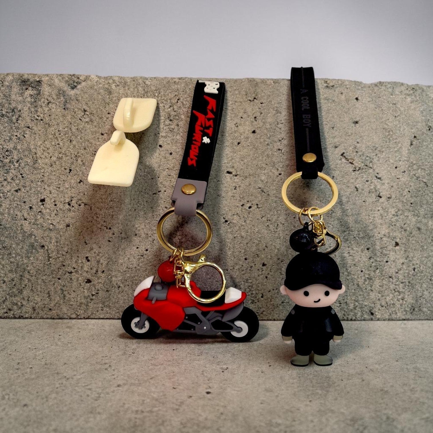 Tiny Tokens red 3D rubber motorcycle keychain with 'Fast & Furious' strap and a black 3D rubber boy keychain with 'A Cool Boy' strap.
