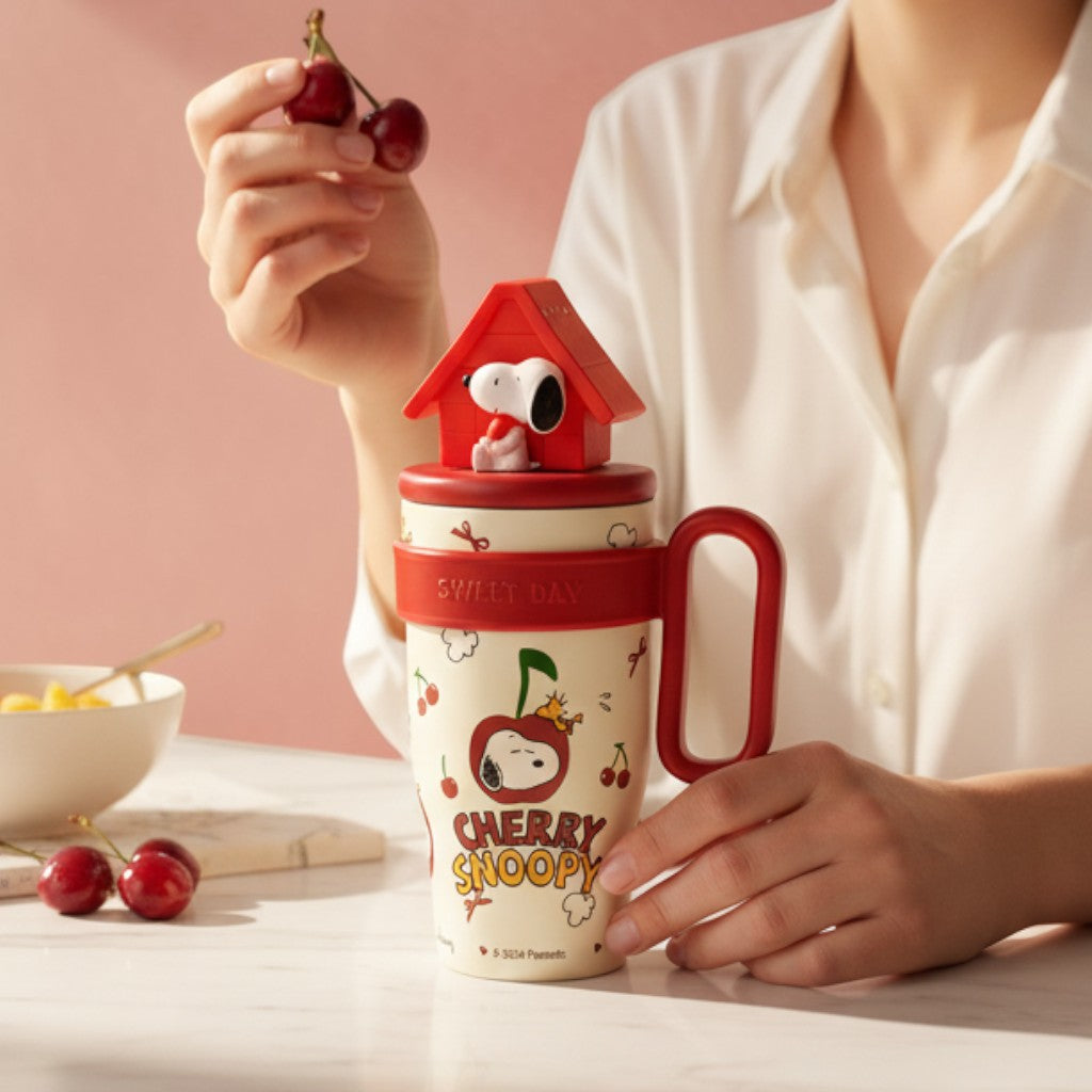 Tiny Tokens Cherry Snoopy kids steel tumbler with 3D doghouse lid, red handle, and straw. Cream background with cherry print.