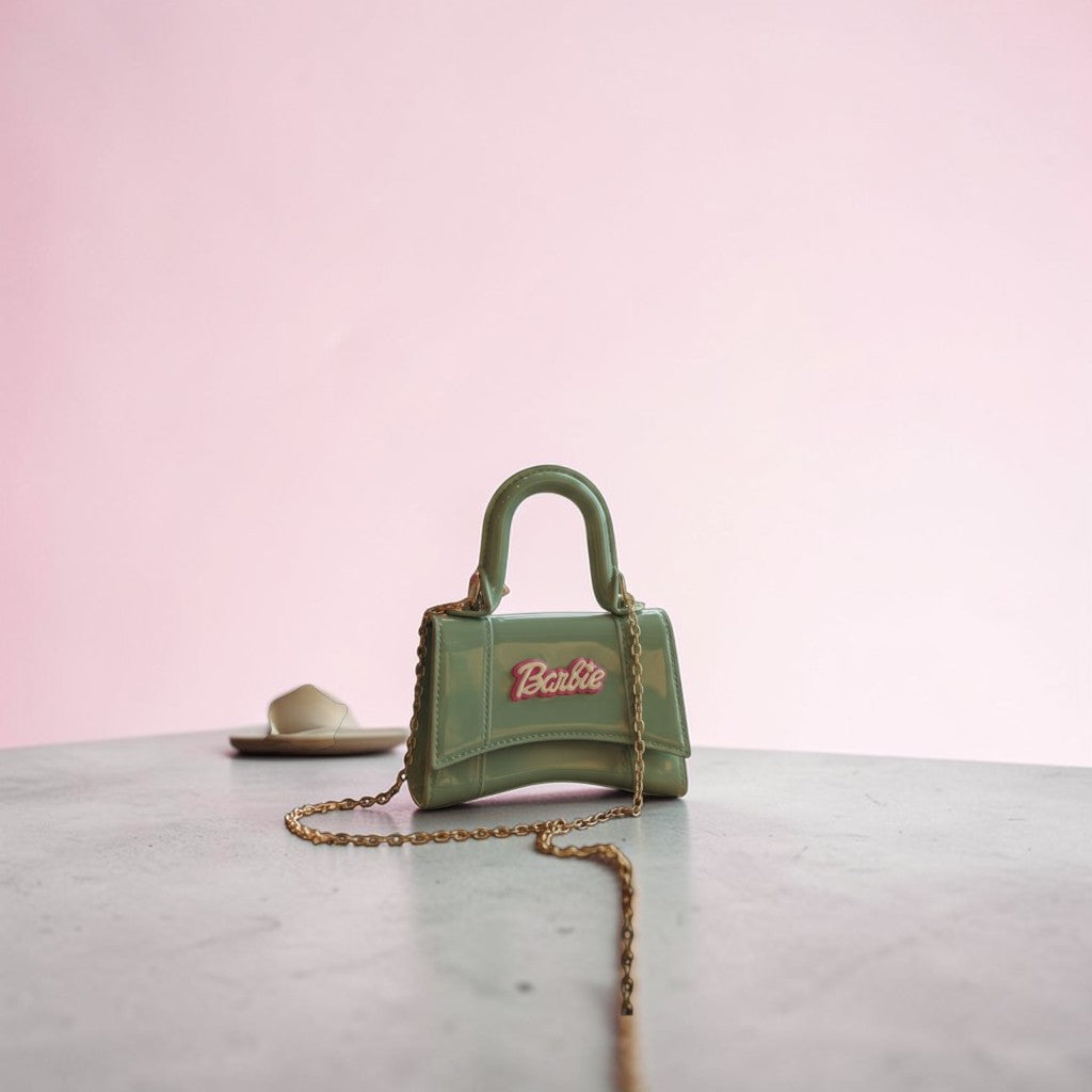 Tiny Tokens mint green patent mini handbag for girls with gold chain strap and Barbie logo.