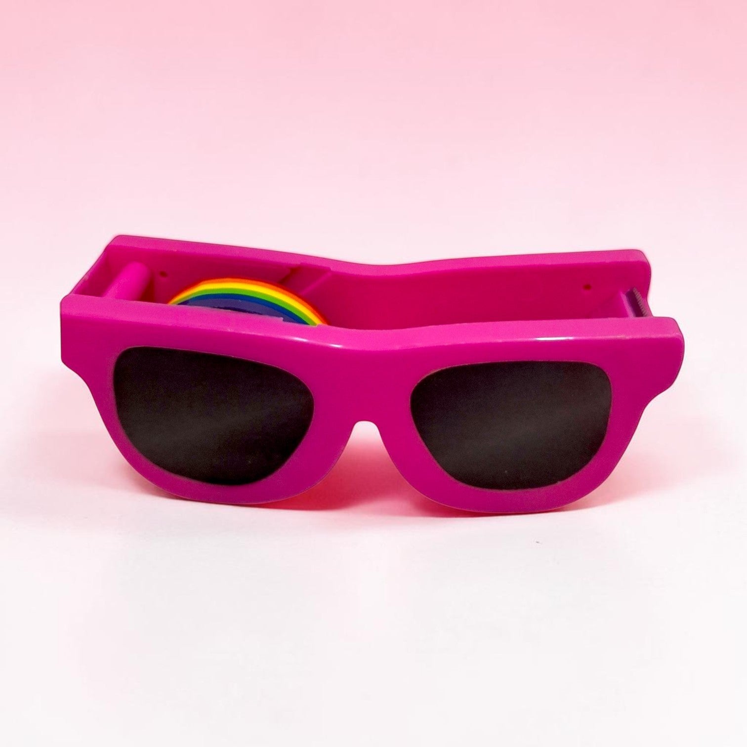 Tiny Tokens pink sunglasses-shaped tape dispenser with rainbow tape, made of durable ABS plastic.