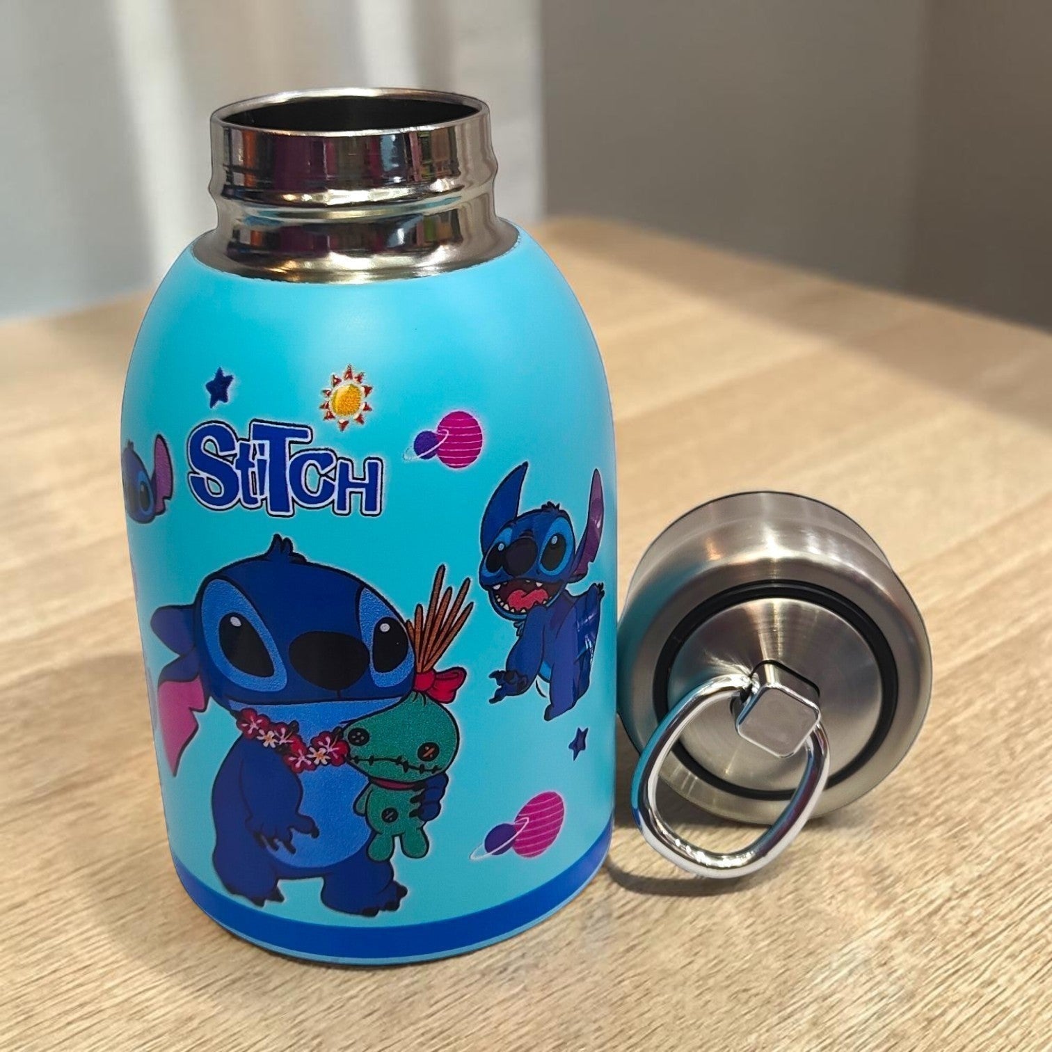 Tiny Tokens sky blue Stitch insulated steel water bottle with screw cap featuring Stitch and Scrump. Ideal for kids.