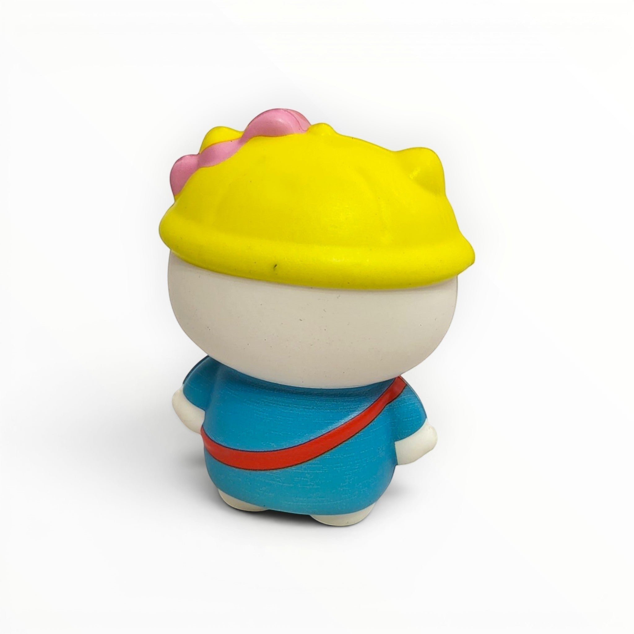 Tiny Tokens white cat squishy toy with yellow hat and blue outfit, featuring a pink bow detail.