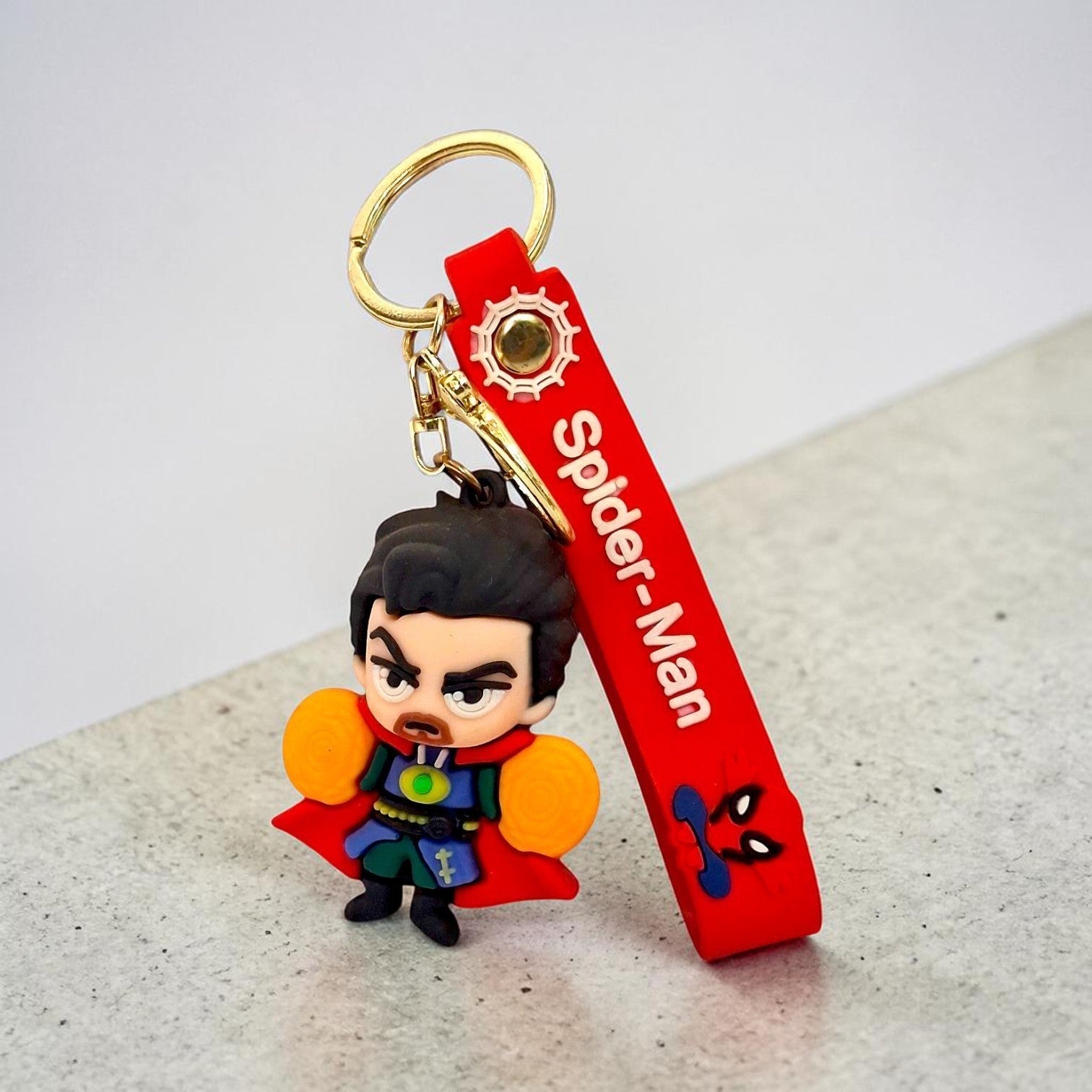 Tiny Tokens Dr. Strange 3D rubber keychain with red Spider-Man strap and gold hardware.