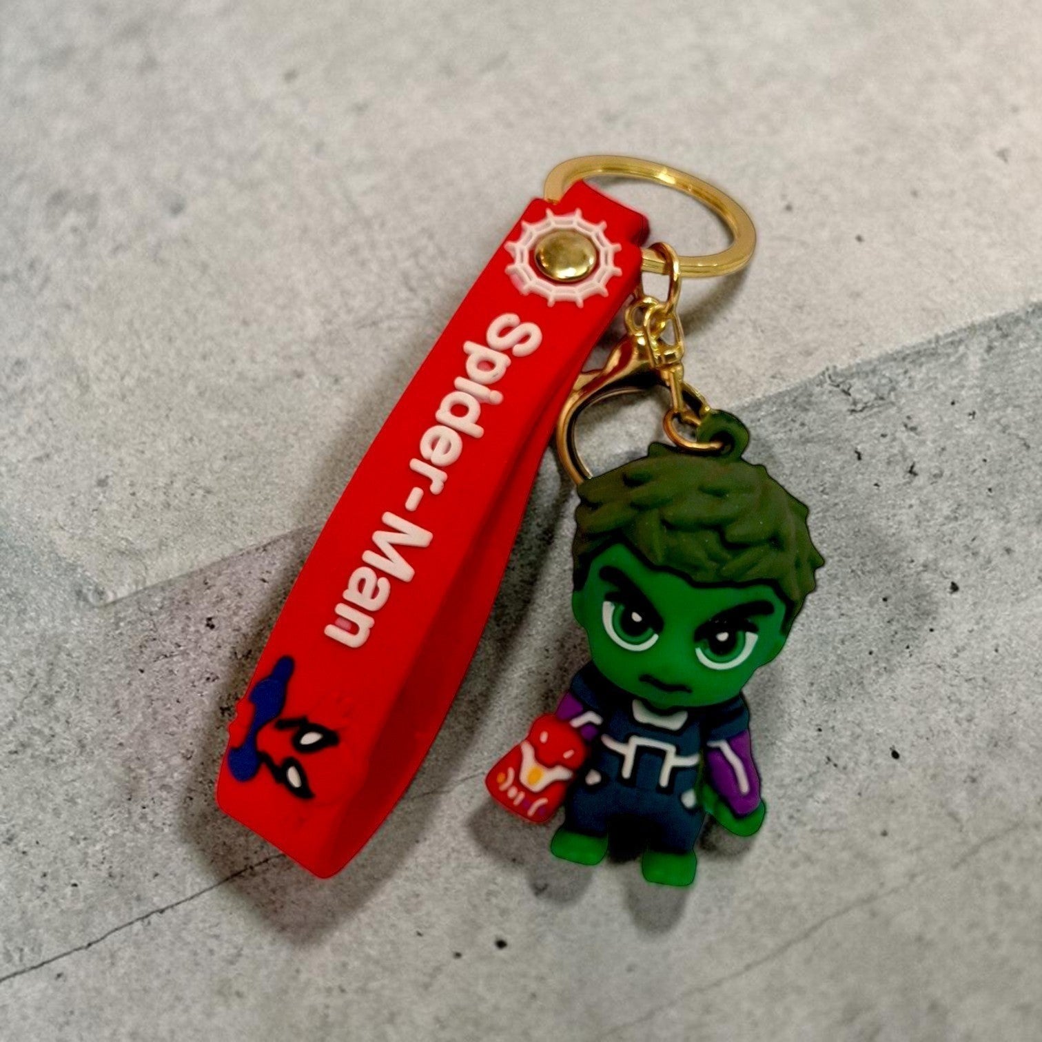 Tiny Tokens Hulk character keychain with red Spider-Man strap and gold hardware.