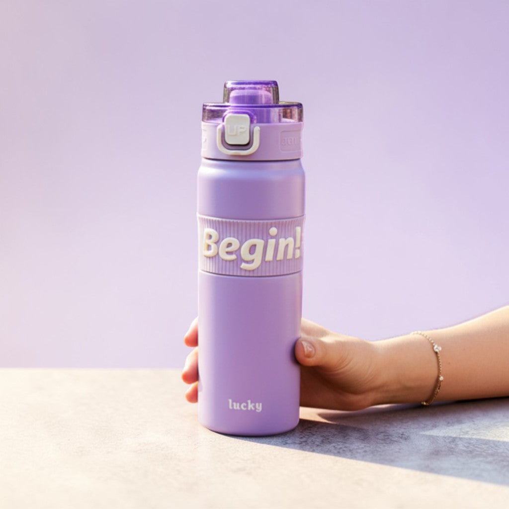Tiny Tokens lavender steel insulated sports bottle with flip lid and motivational 'Begin!' band. Ideal for school and daily use.