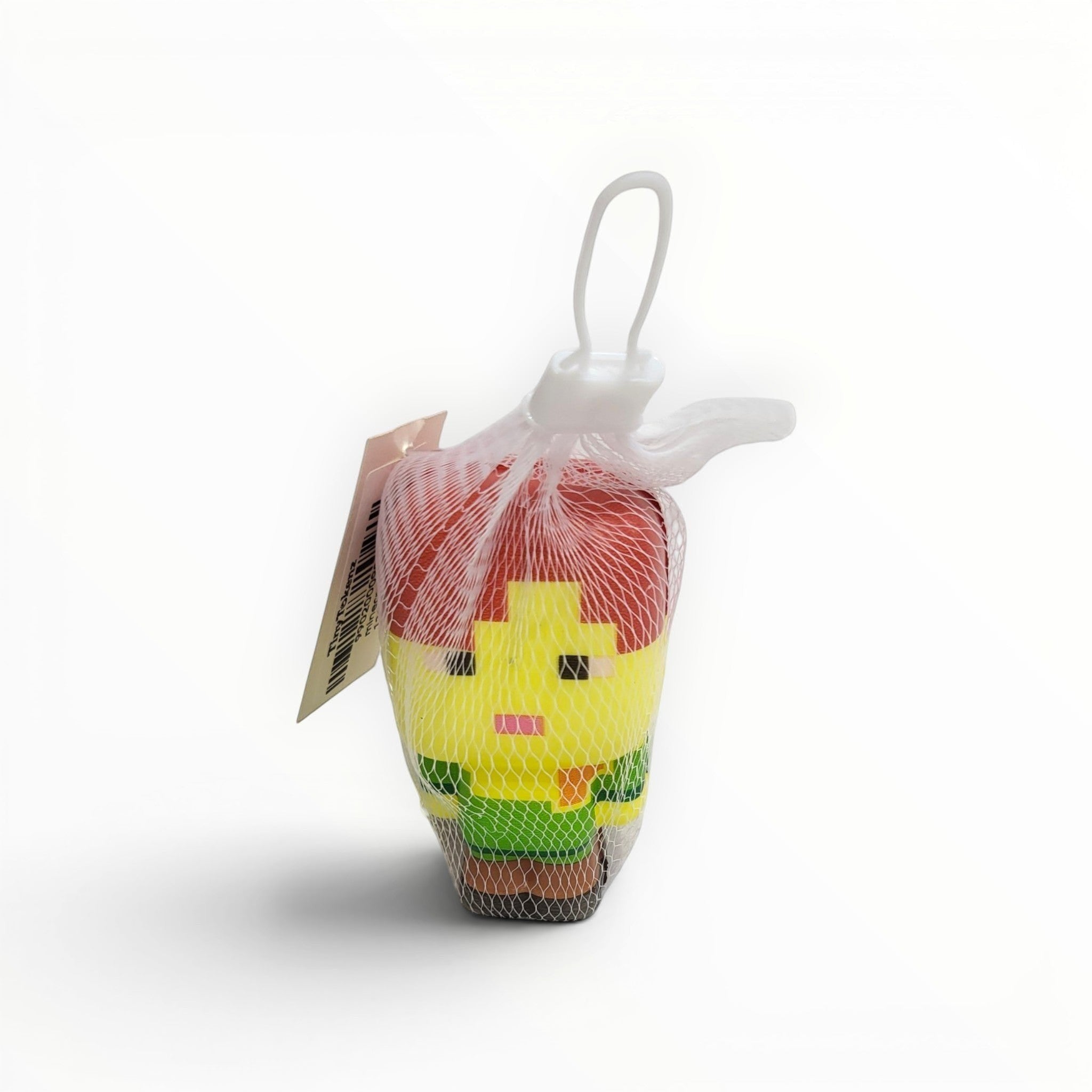 Tiny Tokens Minecraft-style pixel character squeeze toy in red, yellow, green, and brown, made of soft rubber, packaged in a mesh bag.