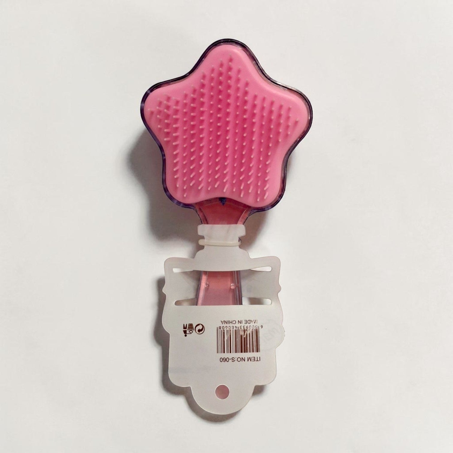 Tiny Tokens pink star-shaped hair comb with soft bristles and glitter confetti inside. Ideal for kids.