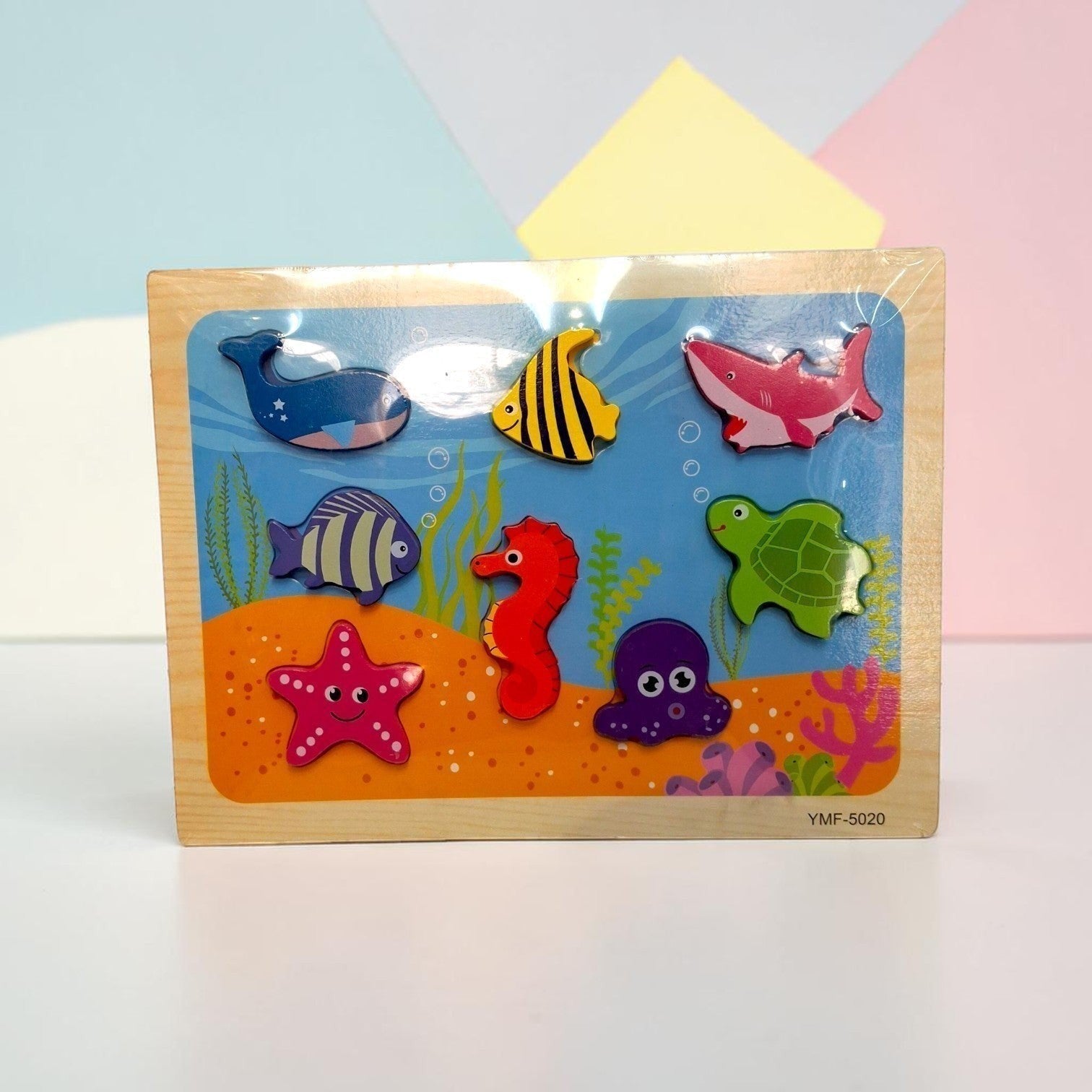 Tiny Tokens wooden sea animal puzzle board with whale, shark, turtle, seahorse, octopus, starfish, and fish pieces.