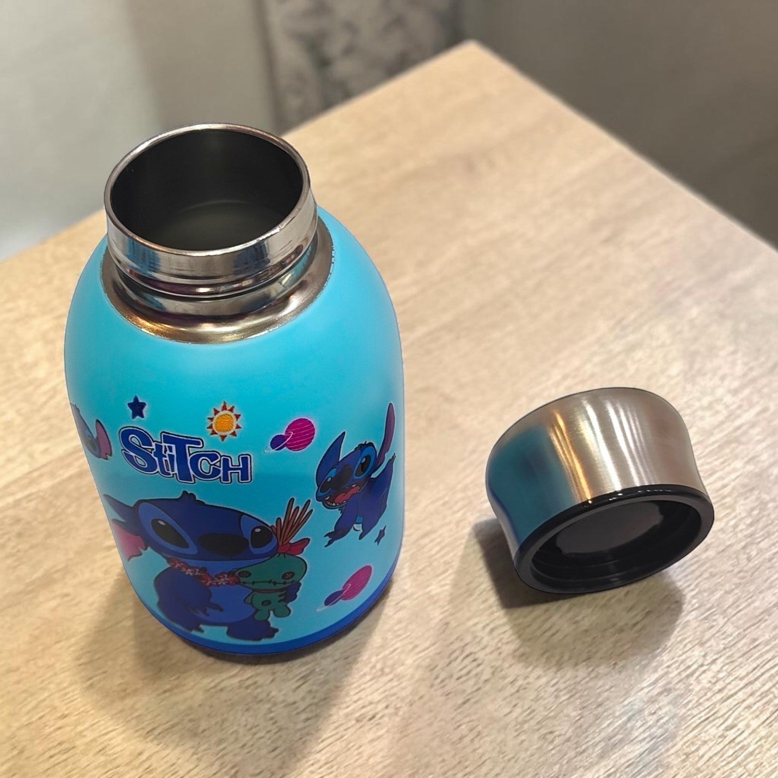 Tiny Tokens sky-blue Stitch mini insulated steel water bottle with screw-top lid, featuring Stitch and planets.